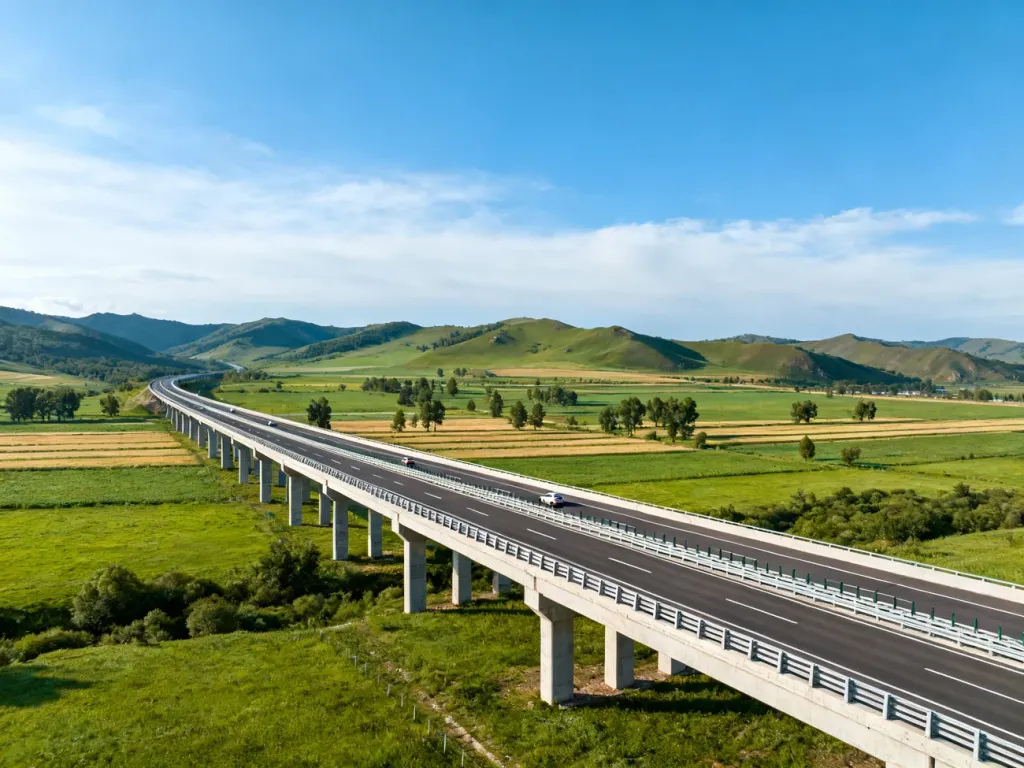 Długi, nowoczesny most autostradowy nad zieloną doliną w słoneczny dzień, pokazujący skalę najdłuższego mostu w Czechach