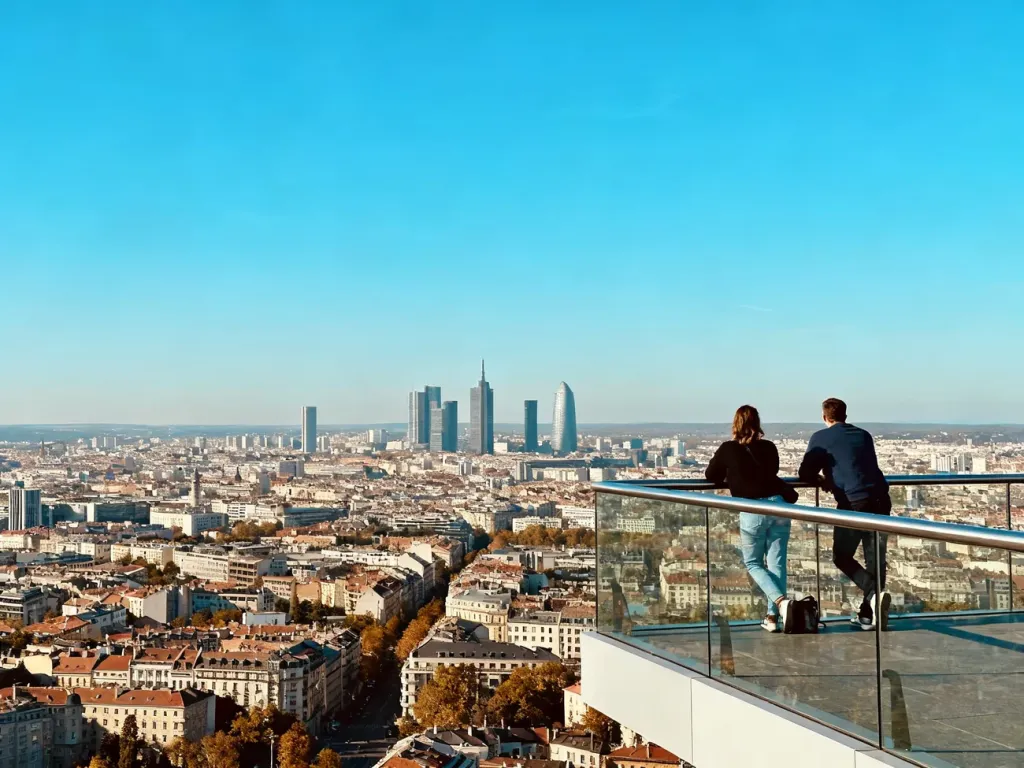 Zwiedzający na tarasie widokowym Varso Tower patrzą na panoramę miasta w słoneczny dzień