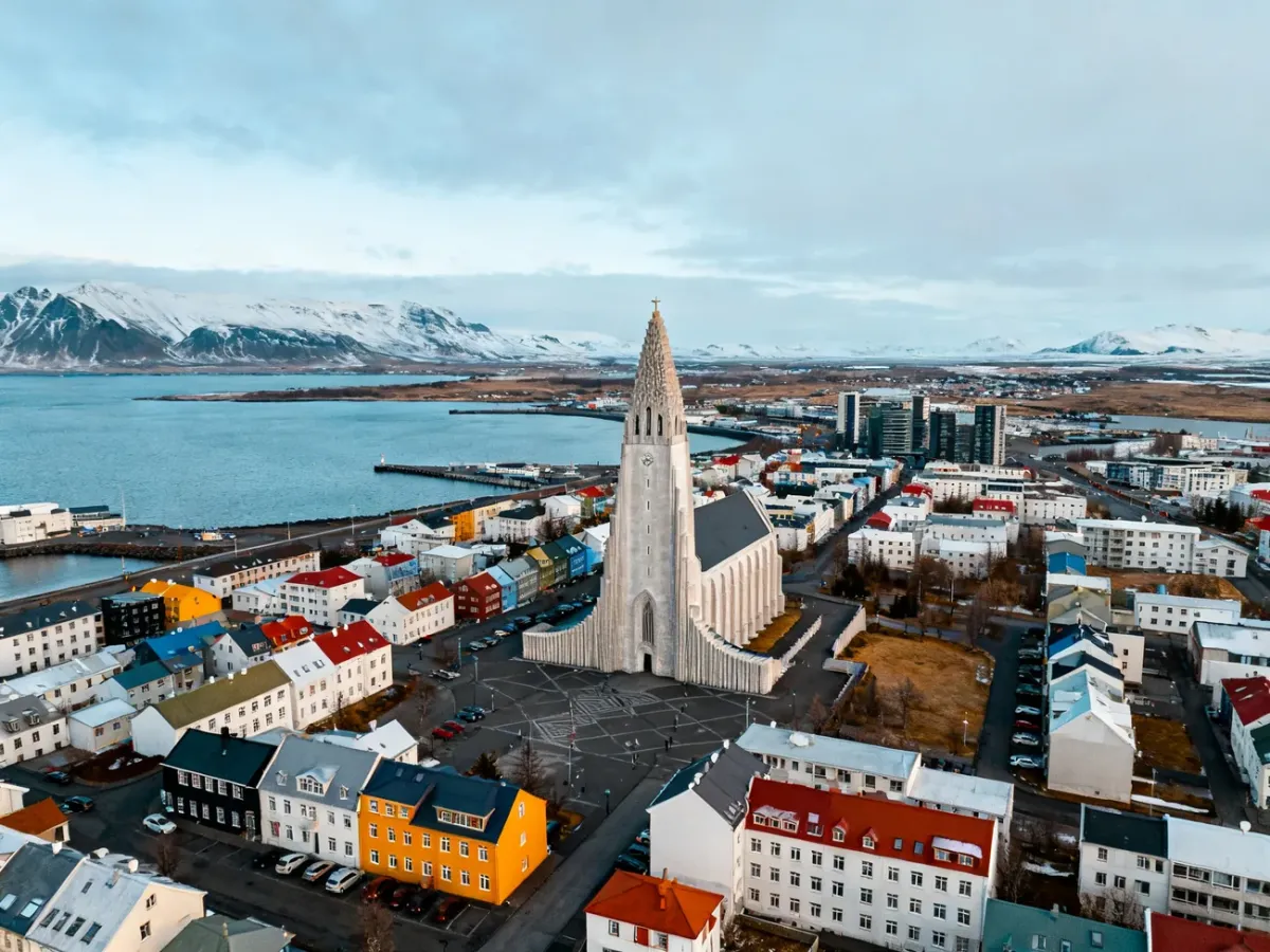 Panorama Reykjaviku z kościołem Hallgrímskirkja, kolorowym centrum i górami w tle