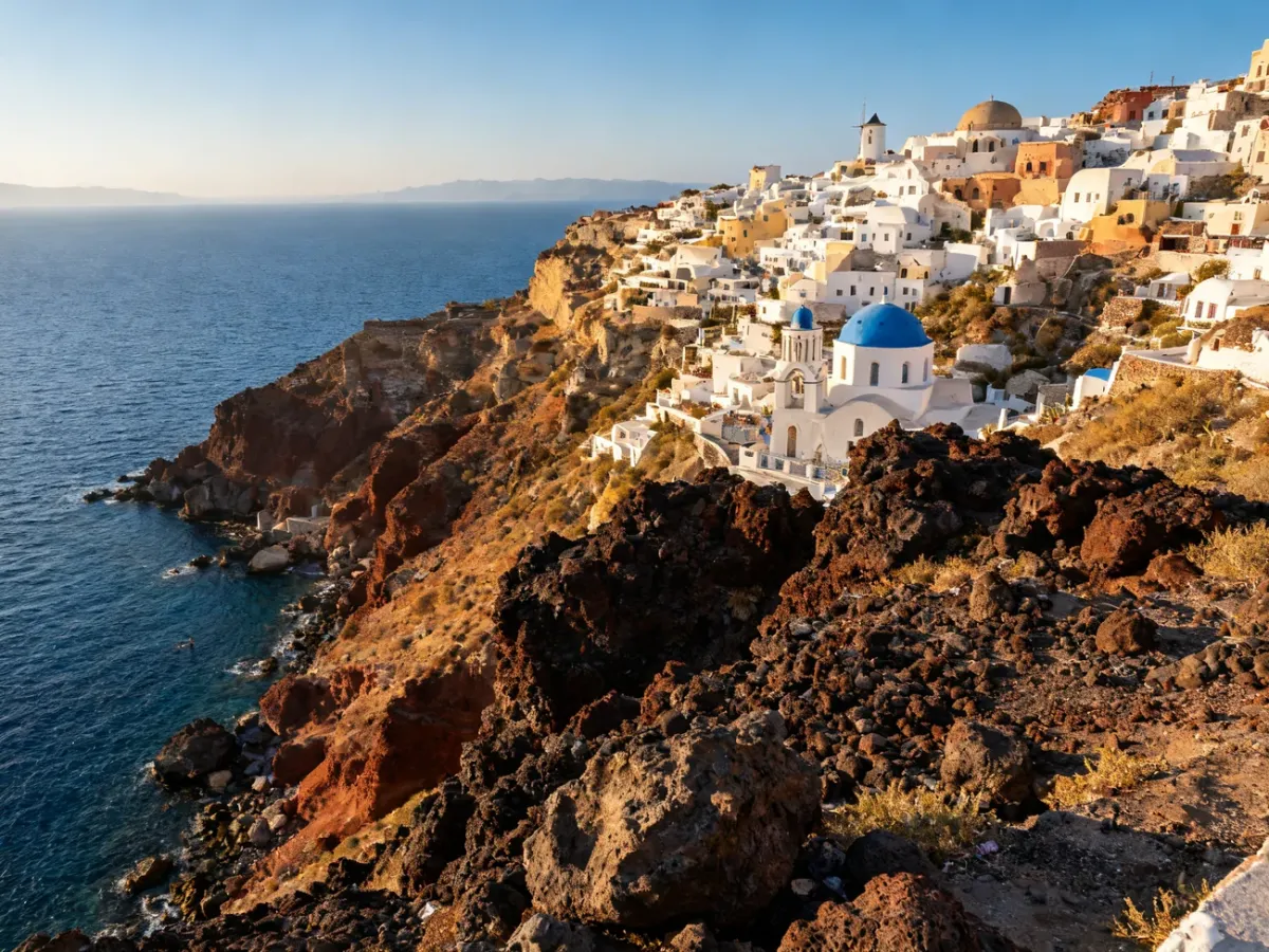 Panoramiczny widok kaldery Santorini z białymi domami i niebieskimi kopułami