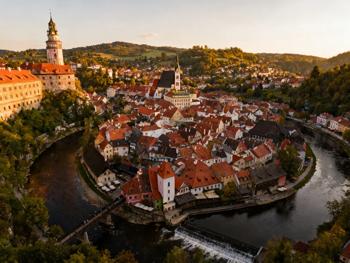Panorama Českiego Krumlova z czerwonymi dachami nad zakolem Wełtawy